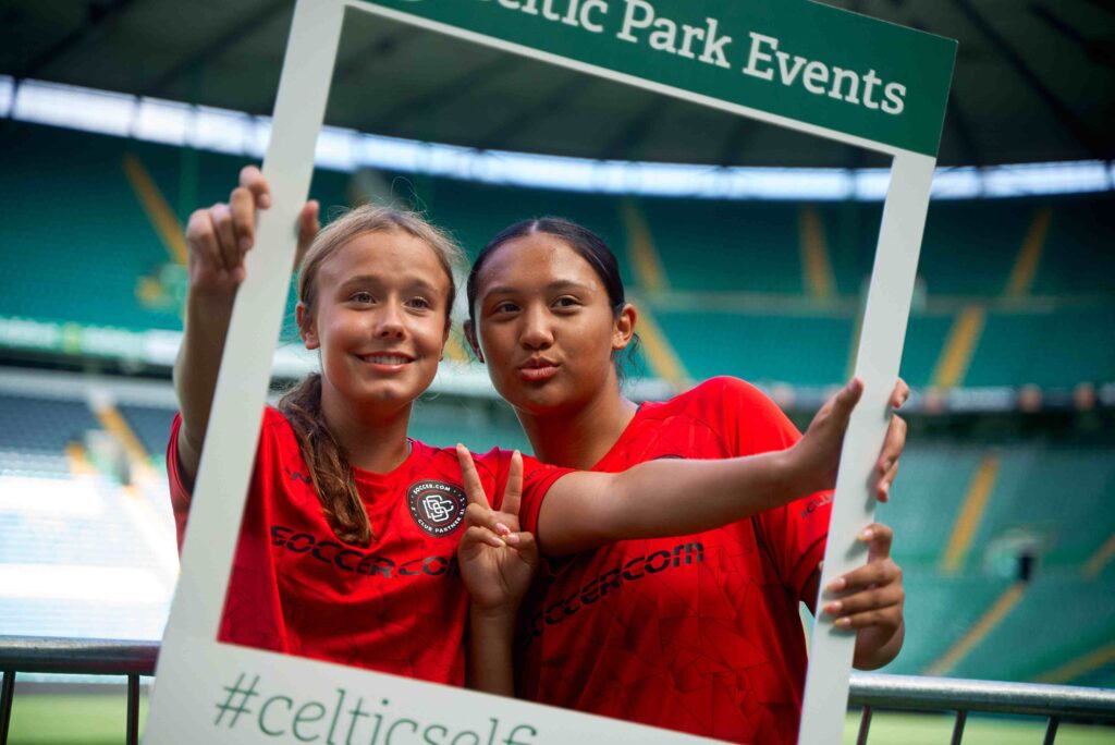 two junior female soccer players pose for a photo during a Celtic Park stadium tour