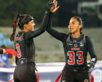 Two female flag footballers celebrate during a game