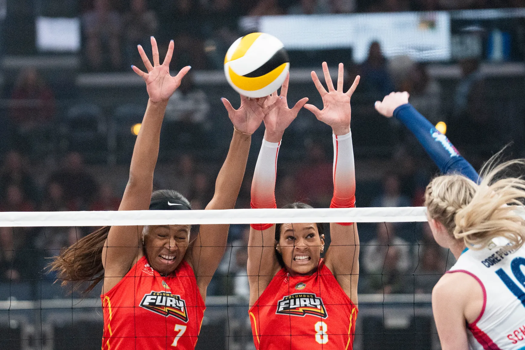 Columbus Fury players blocking a ball in a volleyball match