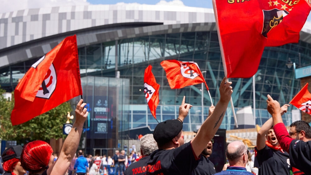 fans waving flags ahead of the 2023 EPCR final at the Tottenham Hotspur Stadium