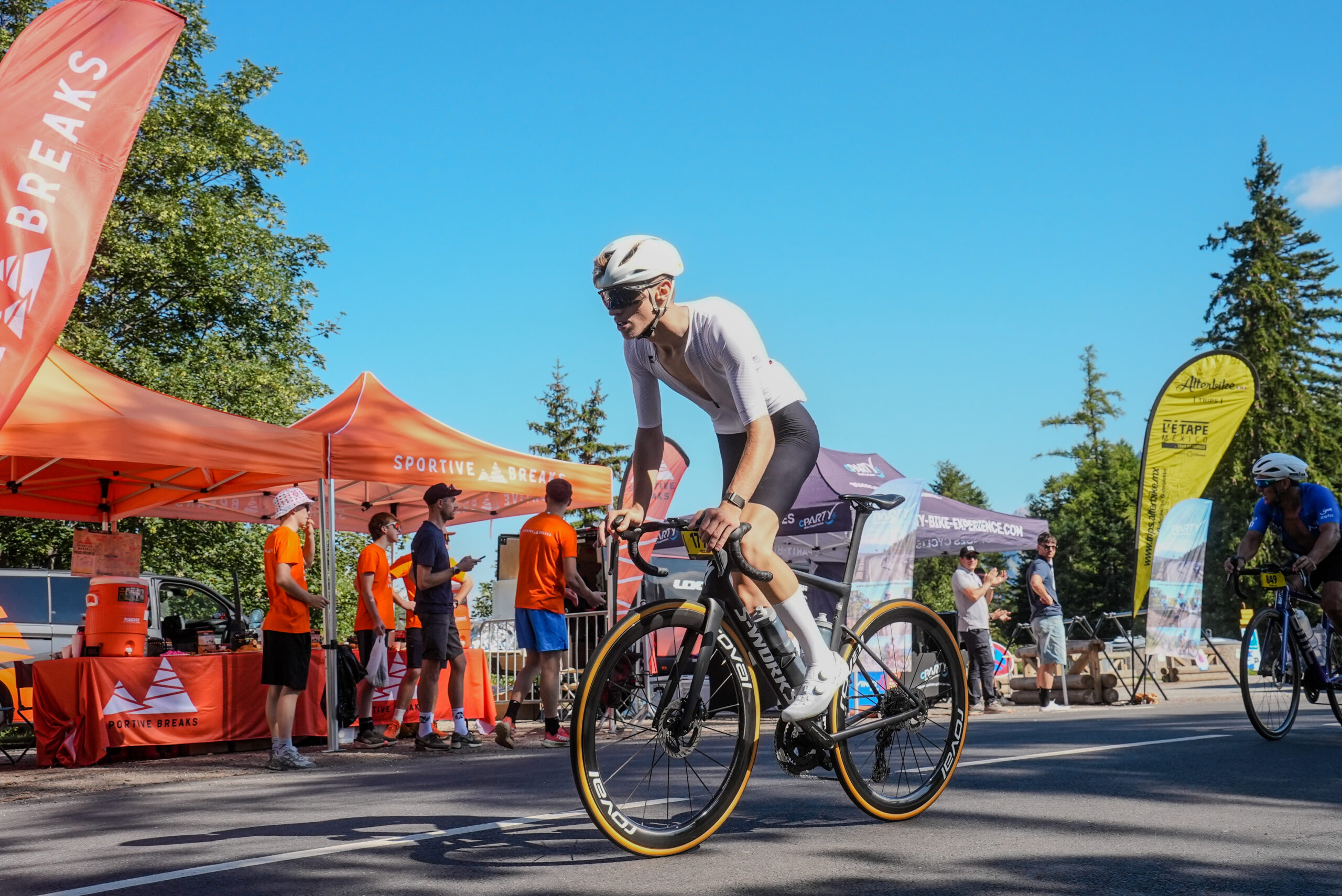 A cyclist kicks on in front of the Sportive Breaks tent at the Etape du Tour